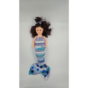 Doll with curly brown hair and mermaid crocheted body with sequins sewn on fin